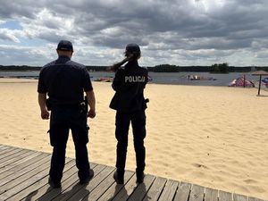 Policjanci rozmawiają z pracownikami wypożyczalni sprzętu wodnego