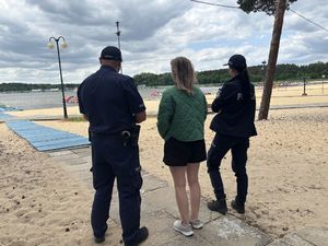Policjanci rozmawiają z pracownikami wypożyczalni sprzętu wodnego